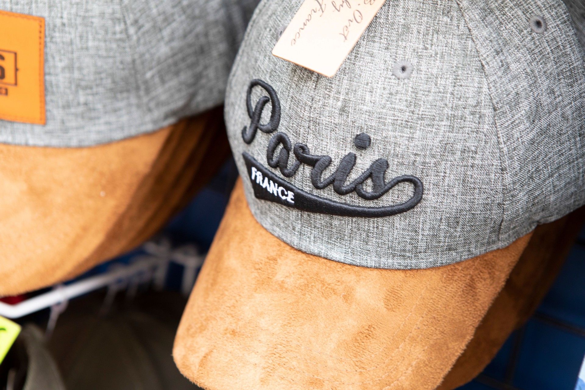 Cappellini da baseball in vendita fuori da un negozio di articoli da regalo a Parigi